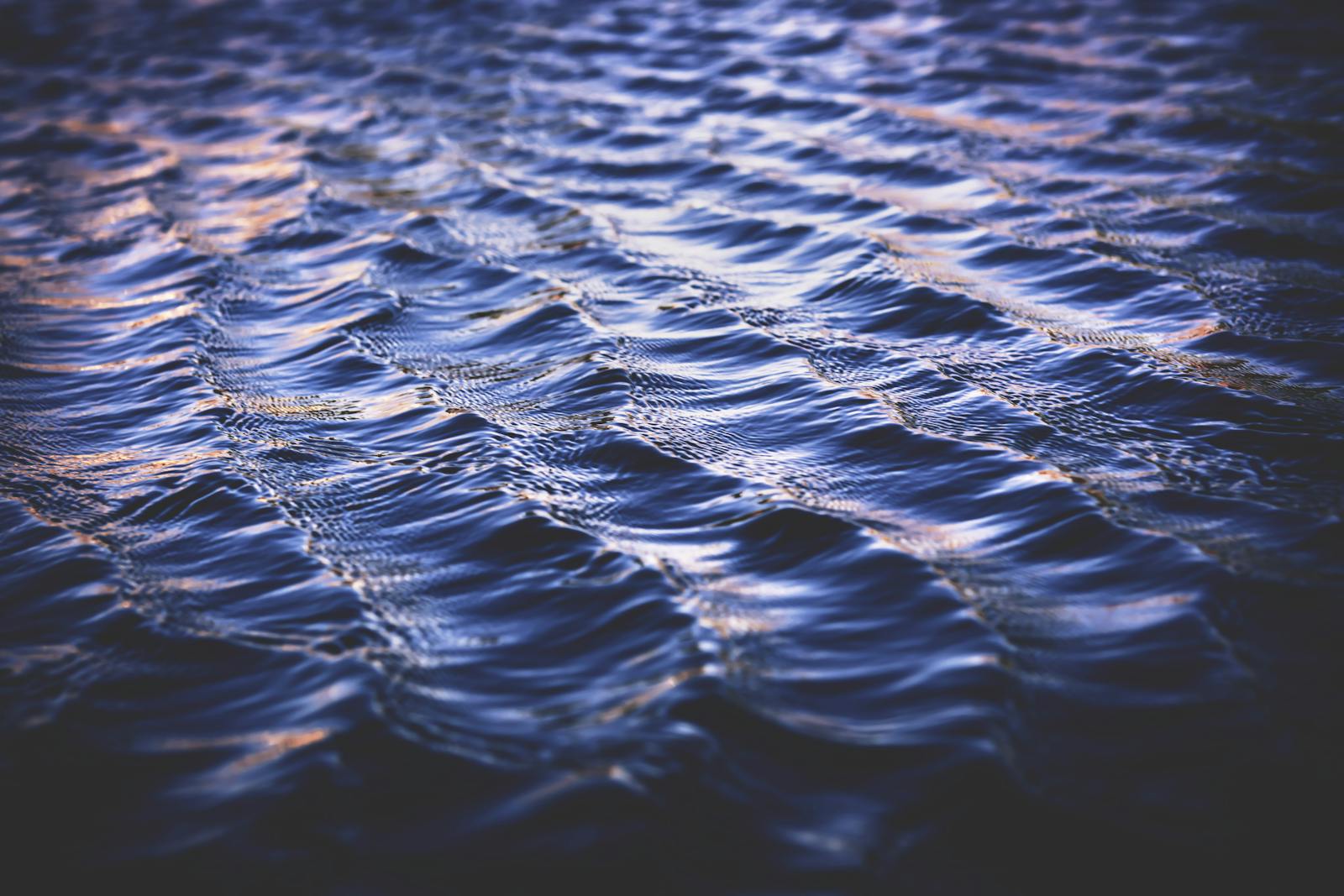 Peaceful ocean waves reflecting the twilight sky, showcasing natural patterns and textures.